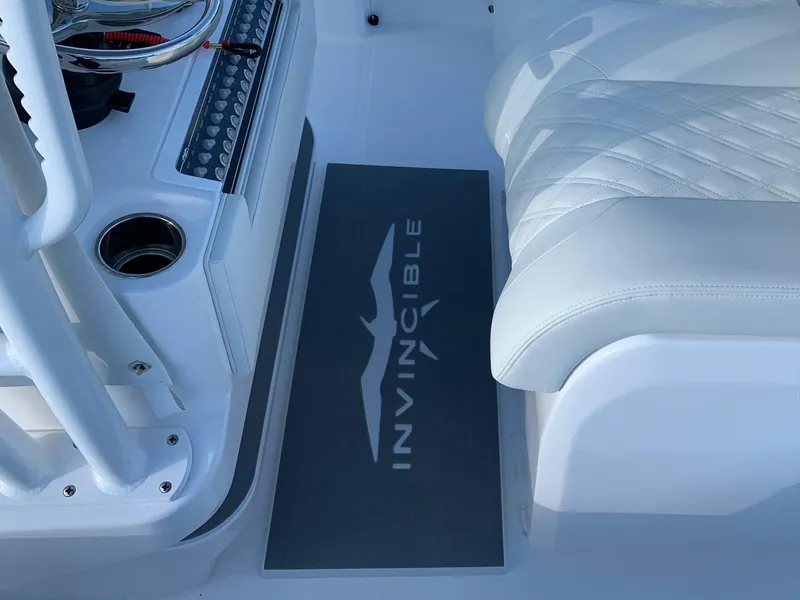 Slide: The Image of 2024 Invincible 33 Open Fisherman boat interior with logo mat and white seating. - 22