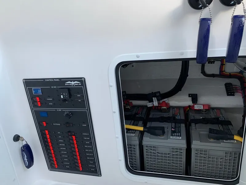 Slide: The Image of 2024 Invincible 33 Open Fisherman control panel and battery compartment. - 24