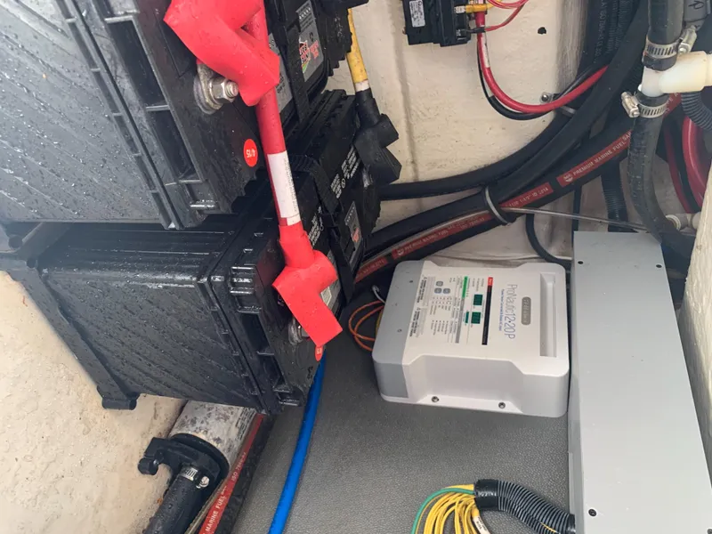 Slide: The Image of Batteries and electrical wiring in a boat's engine compartment, with a charger mounted on the wall. - 31