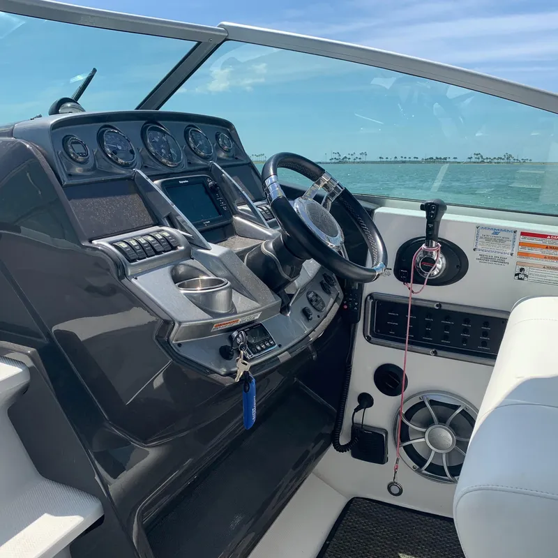 Slide: The Image of The cockpit of the 2015 Monterey 275 Sport Yacht features a modern dashboard with steering wheel and instruments. - 23