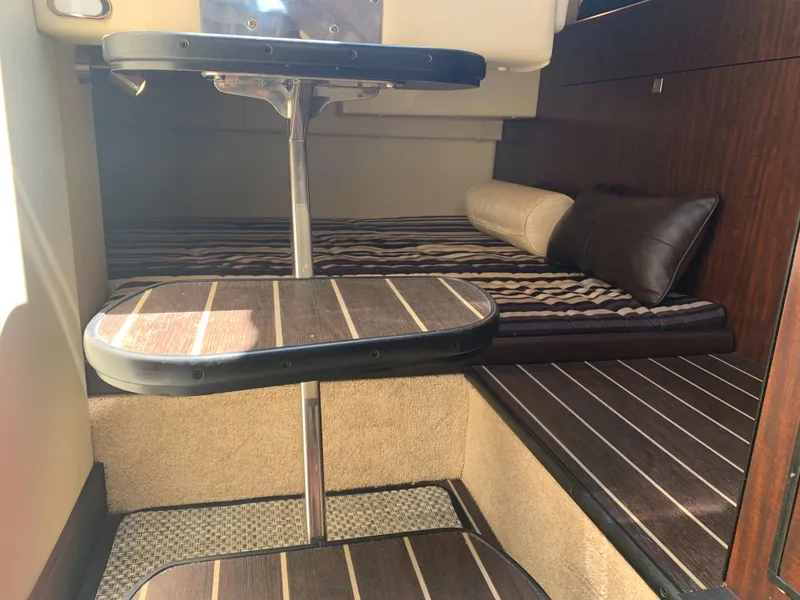 Slide: The Image of Interior of the 2015 Monterey 275 Sport Yacht with striped bedding and wood flooring. - 26