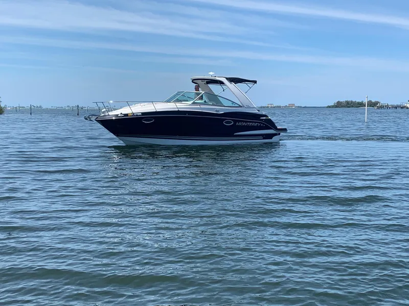 Slide: The Image of A 2015 Monterey 275 Sport Yacht cruising on calm waters under a blue sky. - 33