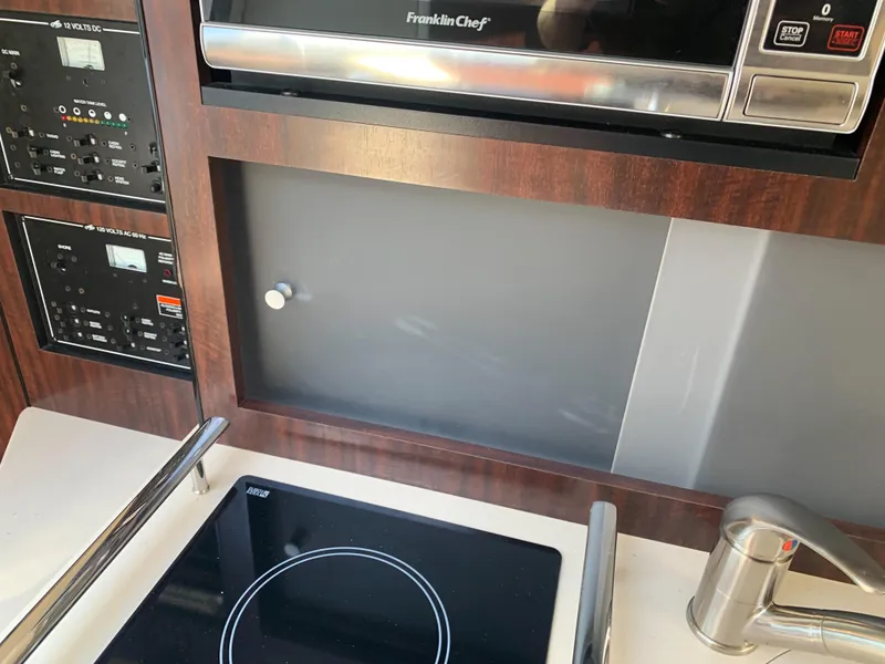 Slide: The Image of The galley of a 2015 Monterey 275 Sport Yacht with stove, microwave, and fixtures. - 39