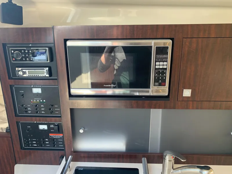 Slide: The Image of The 2015 Monterey 275 Sport Yacht's galley features a microwave and an audio system. - 13