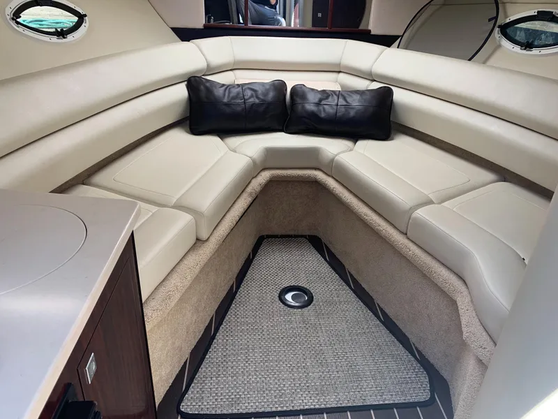 Slide: The Image of Interior of the 2015 Monterey 275 Sport Yacht with cream-colored seating and two black cushions. - 7