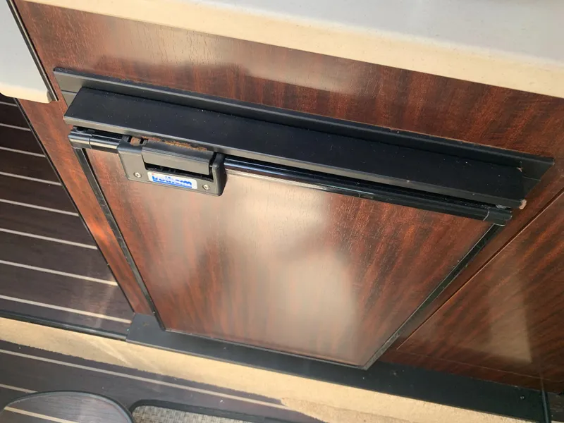 Slide: The Image of A wood-paneled refrigerator in a 2015 Monterey 275 Sport Yacht. - 15