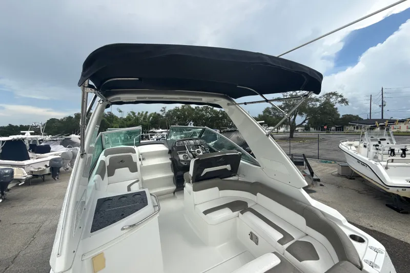 Slide: The Image of 2015 Monterey 275 Sport Yacht with canopy, docked among other boats under a cloudy sky. - 69