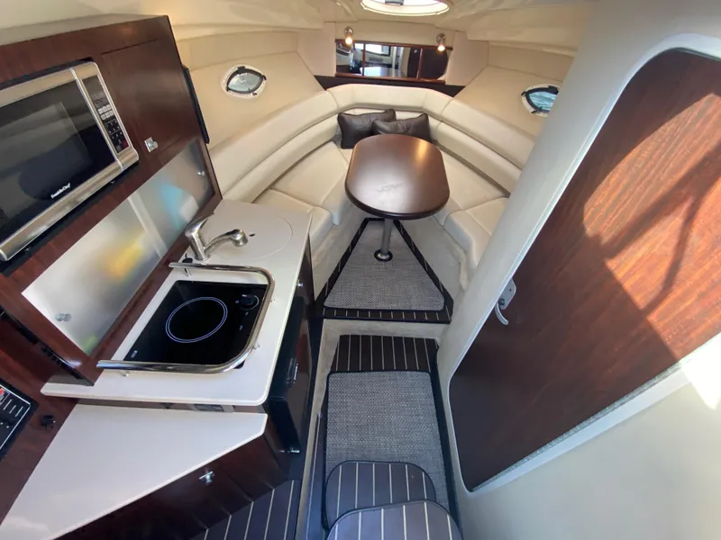 Slide: The Image of Interior of the 2015 Monterey 275 Sport Yacht with kitchenette, table, and seating area. - 49