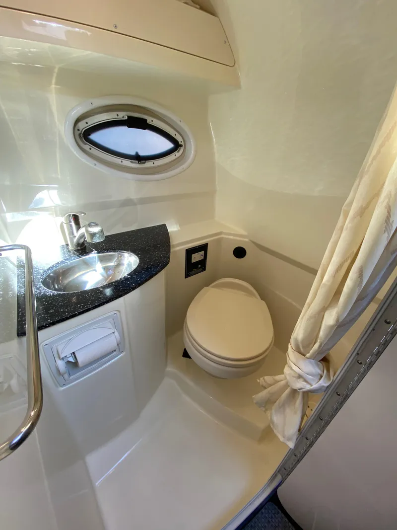 Slide: The Image of The image shows a boat bathroom with a sink, toilet, and porthole. - 48