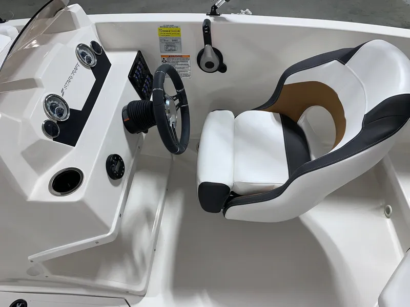 Slide: The Image of 2024 Starcraft SVX 171 boat cockpit with steering wheel and captain's chair. - 5