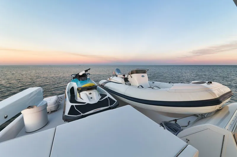 Slide: The Image of 2002 Hatteras Motor Yacht deck with jet ski and inflatable boat at sunset. - 11