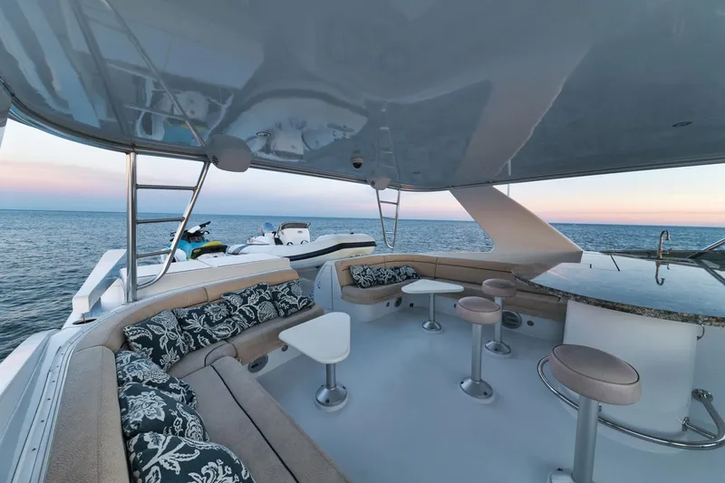 Slide: The Image of Luxurious 2002 Hatteras Motor Yacht deck with seating, ocean view, and sunset sky. - 17