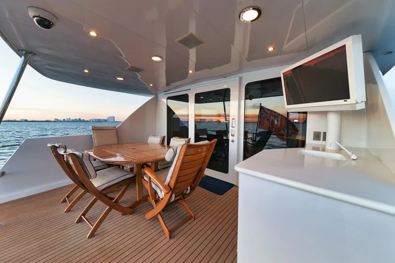 Slide: The Image of Outdoor deck of 2002 Hatteras Motor Yacht with dining area and TV, overlooking water. - 21