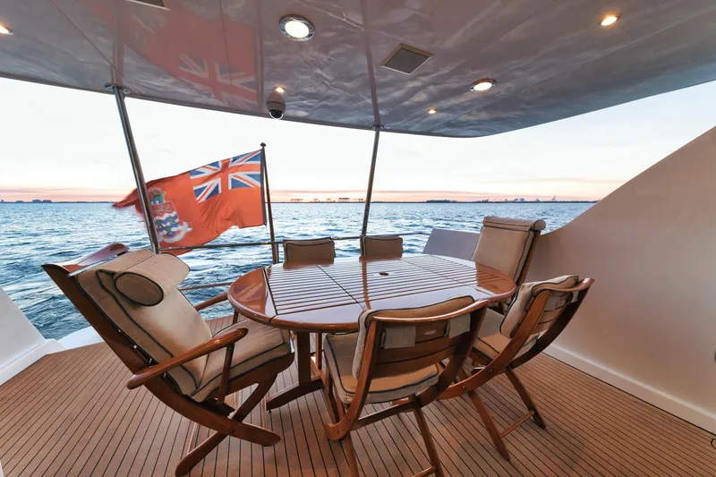 Slide: The Image of Luxurious 2002 Hatteras Motor Yacht deck with dining area and ocean view at sunset. - 22