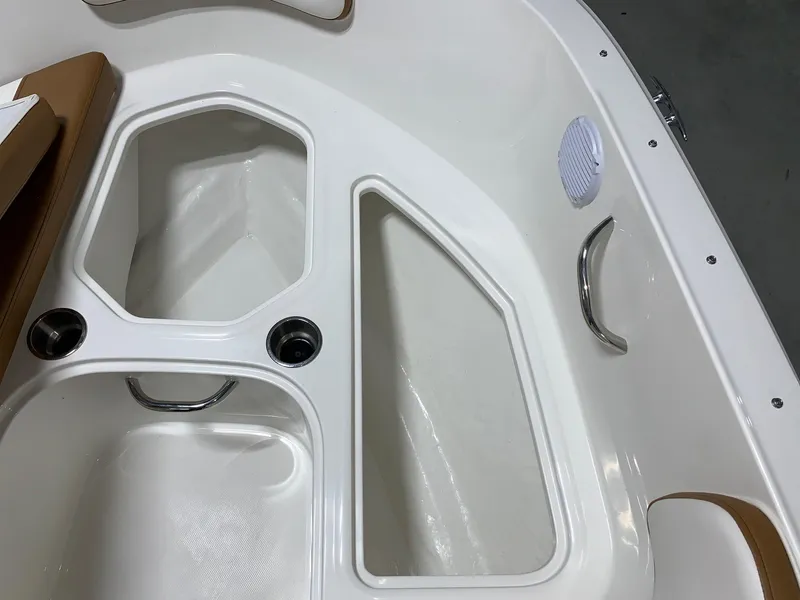 Slide: The Image of 2024 Bayliner VR4 boat interior storage compartments and cup holders. - 16