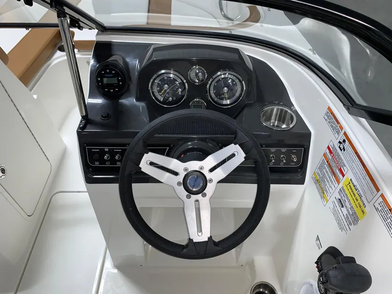 Slide: The Image of 2024 Bayliner VR4 boat dashboard with steering wheel and instrument panel. - 9