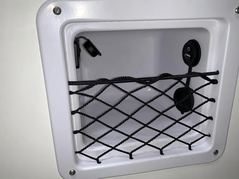 Slide: The Image of Storage compartment with netting on 2024 Bayliner VR4 boat. - 14