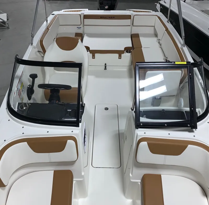 Slide: The Image of 2024 Bayliner VR4 boat interior with tan and white seating, open windshield, and steering console. - 5