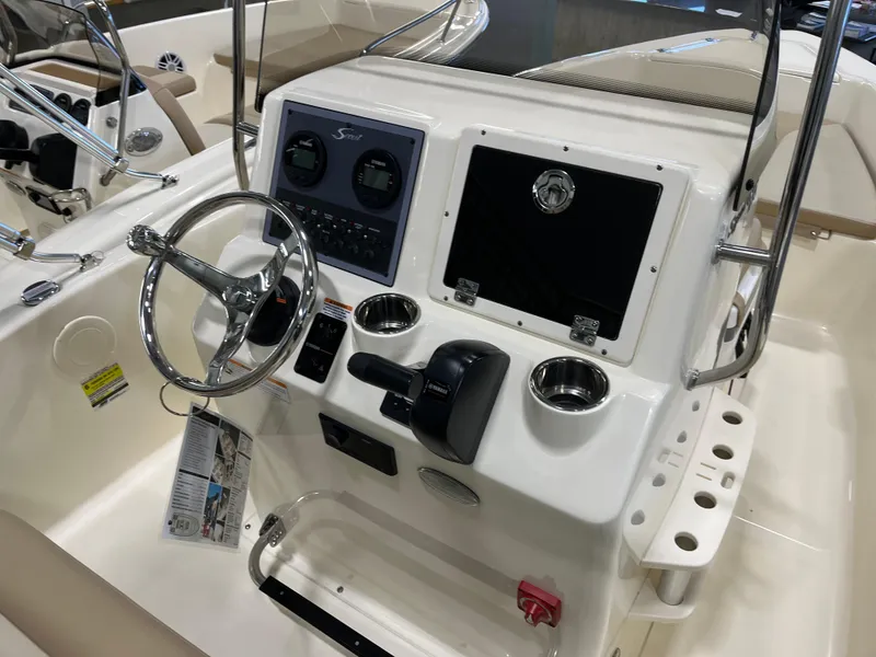 Slide: The Image of 2024 Scout 175 Sportfish boat console with steering wheel and controls. - 4