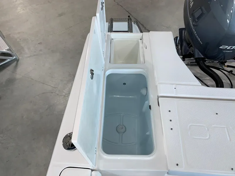 Slide: The Image of 2024 Robalo 226 Cayman boat with open storage compartments and Yamaha outboard motor. - 17