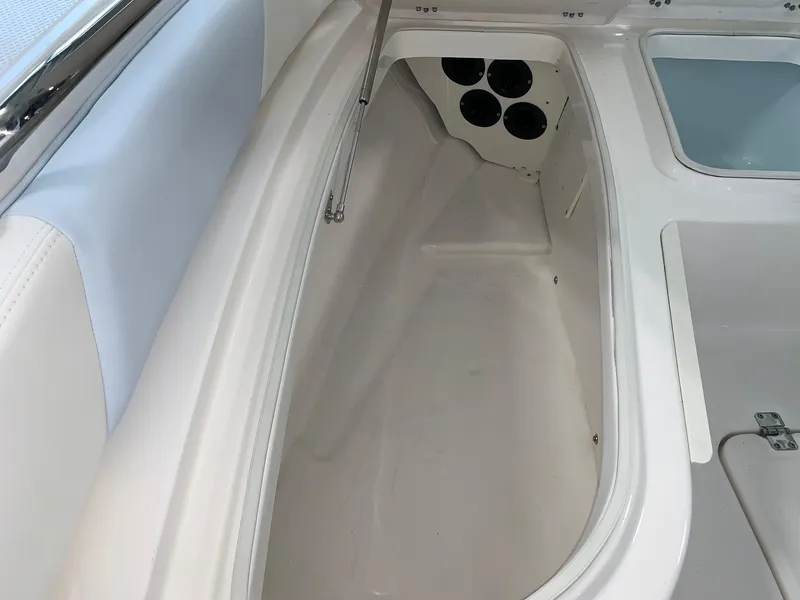 Slide: The Image of 2024 Robalo 226 Cayman boat storage compartment with rod holders. - 9
