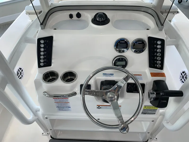Slide: The Image of 2024 Robalo 226 Cayman boat dashboard with steering wheel and control panel. - 13