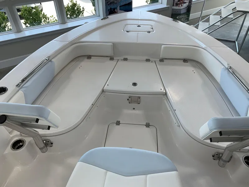 Slide: The Image of 2024 Robalo 226 Cayman boat interior with white seating and storage compartments. - 8