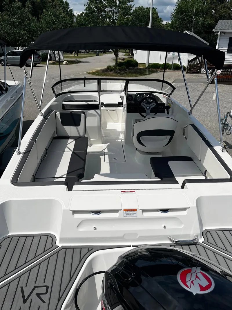 Slide: The Image of 2024 Bayliner VR4 boat with black canopy and spacious seating. - 13