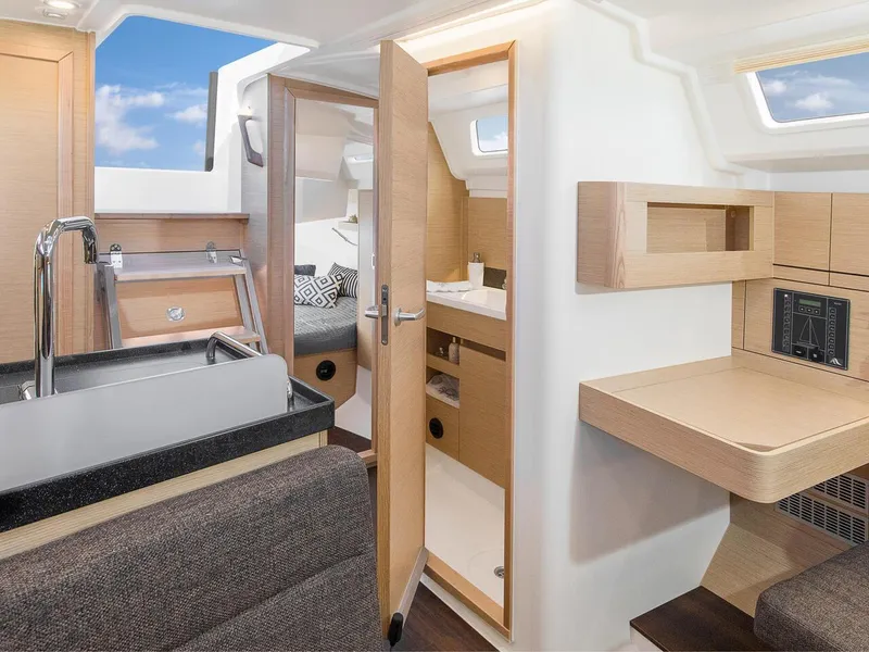 Slide: The Image of 2024 Hanse 348 yacht interior with modern kitchen, cozy seating, and wooden cabinetry. - 16