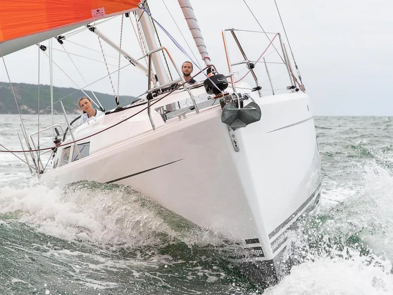 Slide: The Image of 2024 Hanse 348 sailboat navigating through waves with two people onboard. - 25