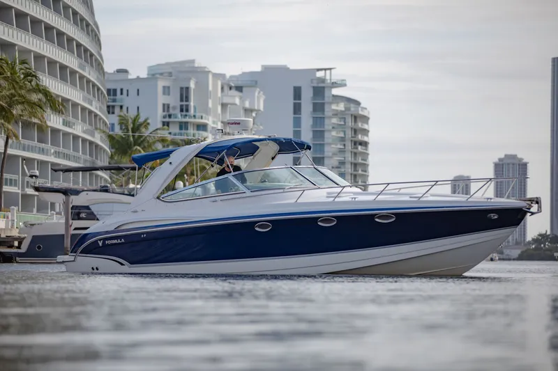 Slide: The Image of 2007 Formula 370 Super Sport boat cruising near modern waterfront buildings. - 16