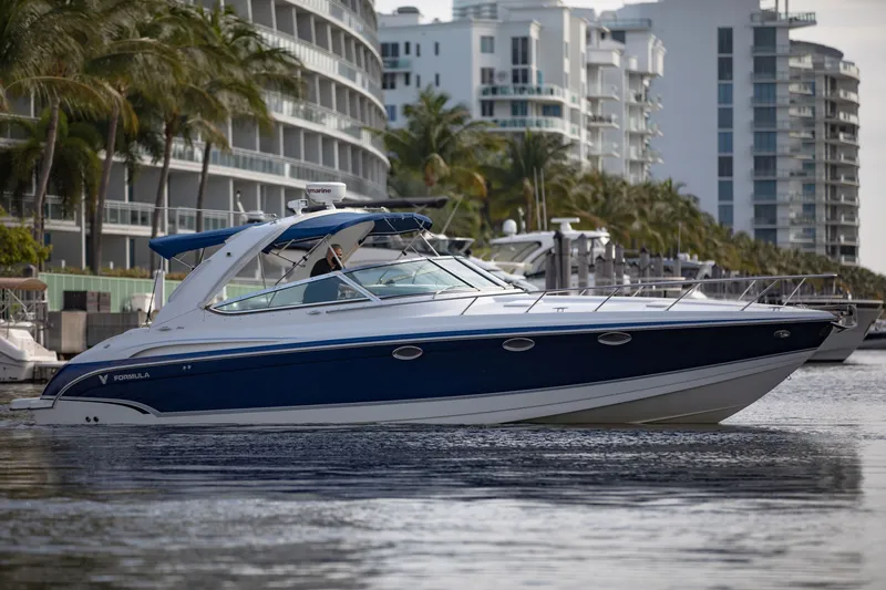 Slide: The Image of 2007 Formula 370 Super Sport boat cruising near modern waterfront buildings. - 24