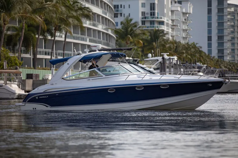 Slide: The Image of 2007 Formula 370 Super Sport boat cruising near modern waterfront buildings. - 25