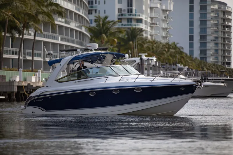 Slide: The Image of 2007 Formula 370 Super Sport boat cruising near modern waterfront buildings. - 26