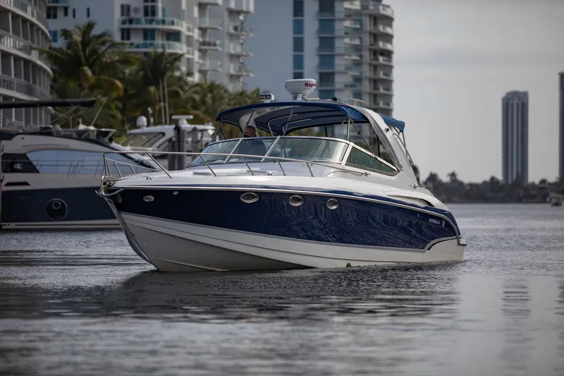 Slide: The Image of 2007 Formula 370 Super Sport boat cruising near modern waterfront buildings. - 27