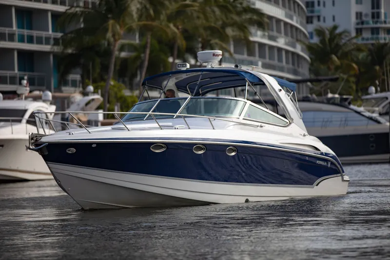 Slide: The Image of 2007 Formula 370 Super Sport boat on water, surrounded by palm trees and buildings. - 30