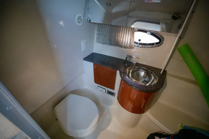 Slide: The Image of 2007 Formula 370 Super Sport boat bathroom with sink, toilet, and porthole window. - 48