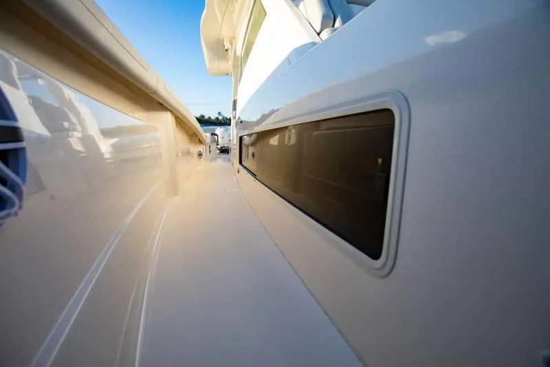 Slide: The Image of Side view of 2025 Scout 425 LXF boat, showcasing sleek design and window detail. - 10