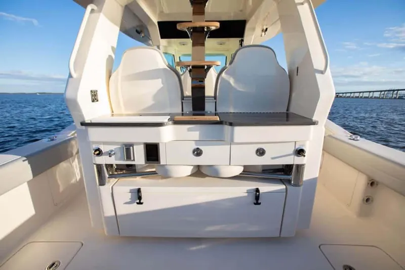 Slide: The Image of 2025 Scout 425 LXF boat interior with seating and storage, on open water. - 4