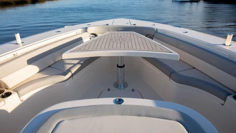 Slide: The Image of 2025 Scout 425 LXF boat interior with seating and table on calm water. - 9