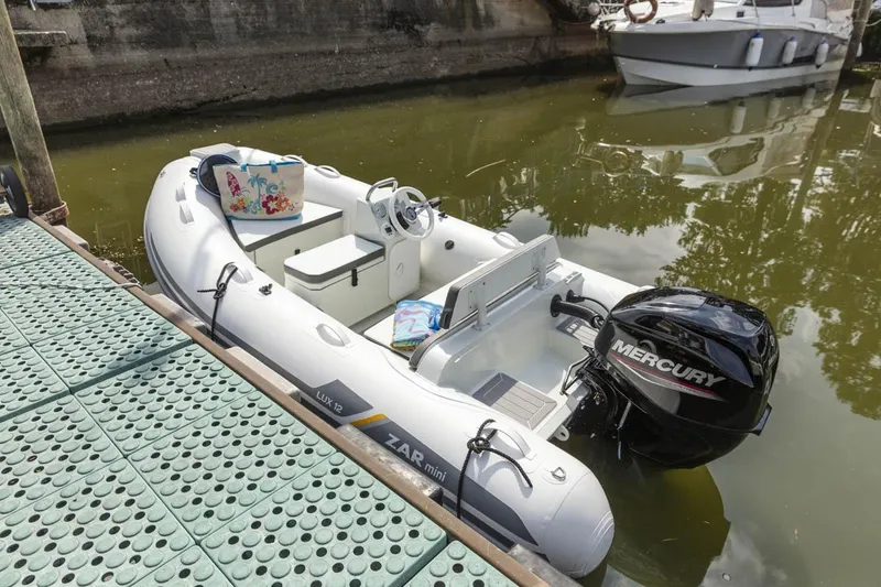 Slide: The Image of 2023 ZAR Mini LUX 12 inflatable boat docked with Mercury outboard motor. - 8
