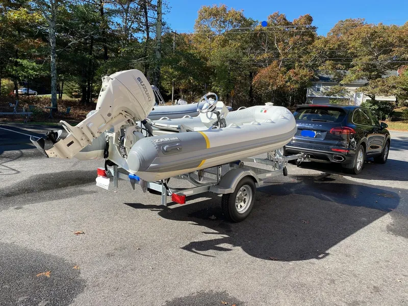 Slide: The Image of 2022 ZAR Mini 13 HDL inflatable boat on trailer, hitched to a black SUV. - 10