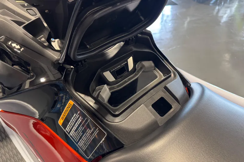 Slide: The Image of 2025 Kawasaki STX160X storage compartment with warning label and sleek design. - 10