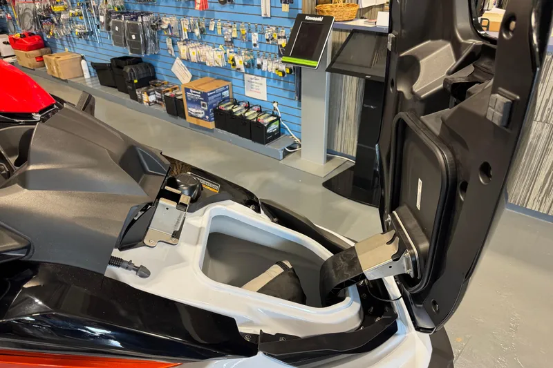 Slide: The Image of 2025 Kawasaki STX160X jet ski with open storage compartment in showroom. - 5