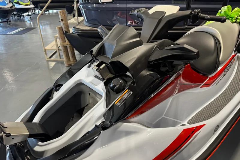 Slide: The Image of 2025 Kawasaki STX160X jet ski in showroom, featuring sleek design and storage compartment. - 6