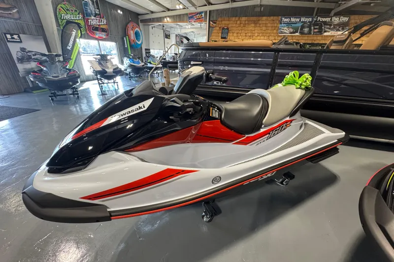 Slide: The Image of 2025 Kawasaki STX160X jet ski in showroom, featuring sleek red and white design. - 7