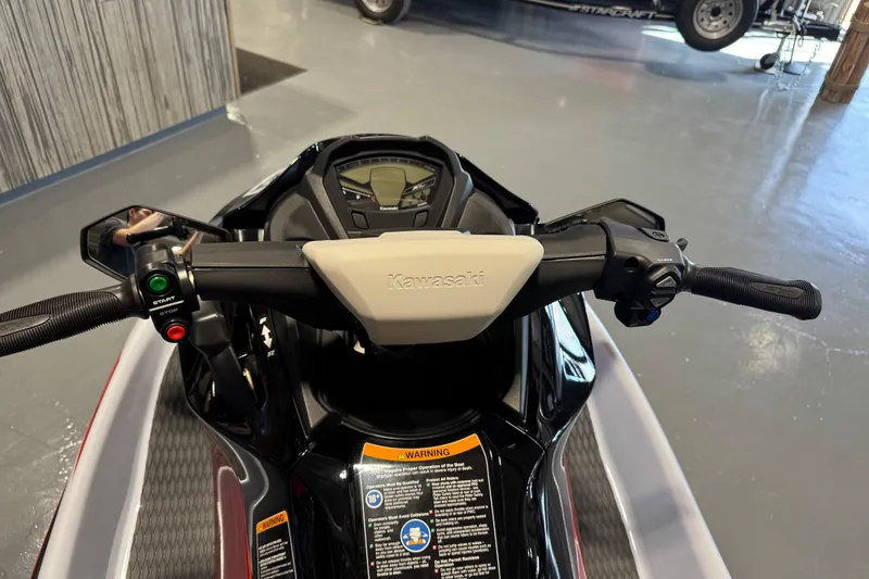 Slide: The Image of 2025 Kawasaki STX160X jet ski handlebars and dashboard in showroom. - 9