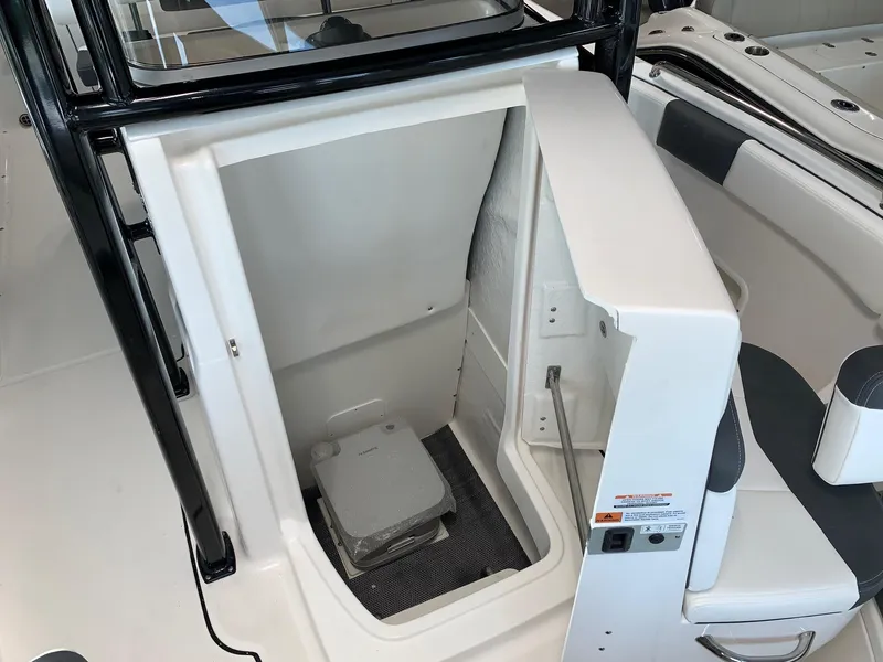 Slide: The Image of 2024 Robalo R222 boat interior with a built-in toilet compartment. - 7