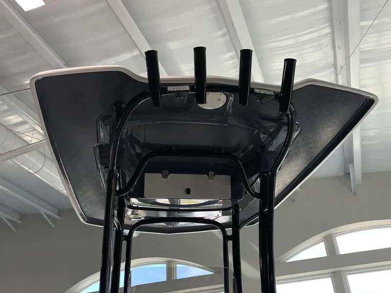 Slide: The Image of 2024 Robalo R222 boat T-top with rod holders in indoor showroom. - 3