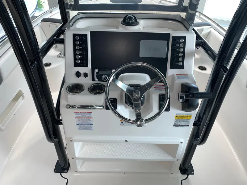 Slide: The Image of 2024 Robalo R222 boat helm with steering wheel and control panel. - 9